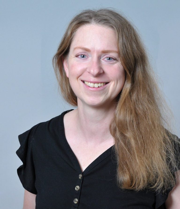 Foto von Franziska Niedermeyer Blonde Frau, Haare schulterlang und offen, blaue Augen, lacht in die Kamera, schwarzes kurzärmeliges Shirt